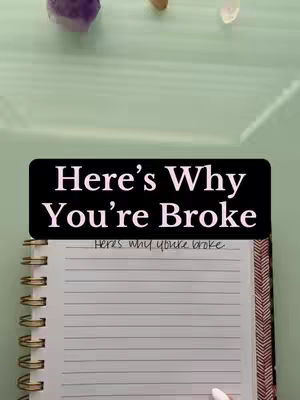 A vertical shot features a notebook with lined paper, open to a blank page, set against a mint-green background. Overlaid on the notebook is a black banner with white text that reads, "Here's Why You're Broke". Above the notebook, a glimpse of a light-green surface is visible, with a few decorative stones.