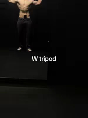 A man with a muscular physique stands in front of a dark background, with text overlayed. The man stands in a posed, flexing position.