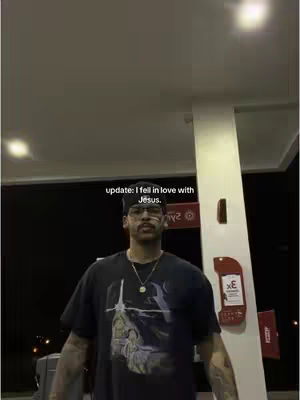 A man stands at a gas station at night, illuminated by overhead lights and a visible gas pump. The top of the image has a text overlay.