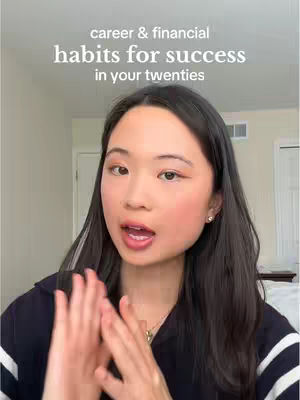 A young woman is centered in the frame, looking towards the camera with an open mouth, suggesting she is speaking. Above her, the text 'career & financial habits for success in your twenties' is displayed in a clean, sans-serif font. The background is a lightly blurred interior space, with a simple white door frame and elements of a room, creating a neutral backdrop that keeps the focus on the subject and the message.