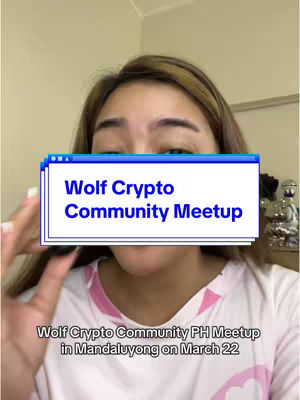 A woman is facing the camera with a text overlay in front of her face. The overlay is a light blue rectangle with the words "Wolf Crypto Community Meetup" in bold white letters. The woman has light brown hair and is wearing a white and pink patterned top. Behind her is a blurry background of a neutral-colored room.