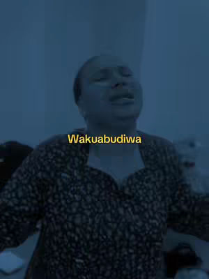 The cover image is a medium shot featuring a woman looking upwards with an emotional expression, possibly singing or praying. The background is a solid, dark blue. Text overlayed in the center of the image reads "Wakuabudiwa" in a yellow font.