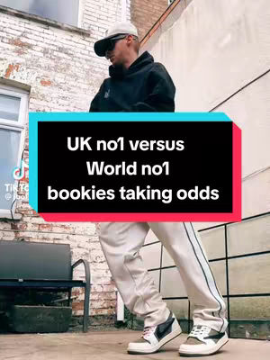A man wearing a baseball cap and sunglasses stands in front of a brick building with a sign in the center reading "UK no1 versus World no1 bookies taking odds."