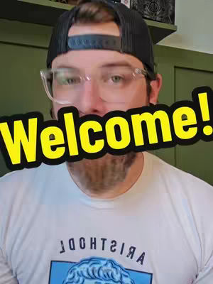 A man with a beard wearing glasses and a hat is the central focus of this video cover. The words 'Welcome!' are overlaid in large yellow text with a black border, partially obscuring his face. He is wearing a white t-shirt with a graphic.