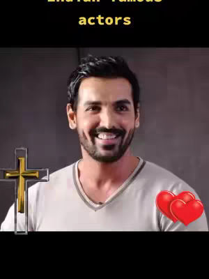 A man with a smiling face is the focus of the image. In the background there is a dark wall, the image contains symbols like the cross and hearts. The man wears a white shirt. There is text at the top of the image.