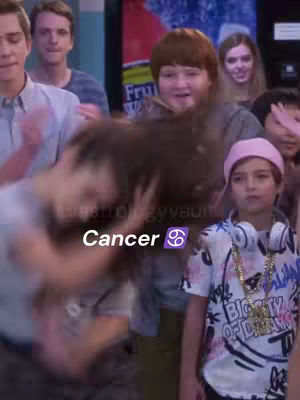 A group of people are in a room. A person in the foreground is having their hair messed up. The text overlay 'Cancer ♋️' is present.