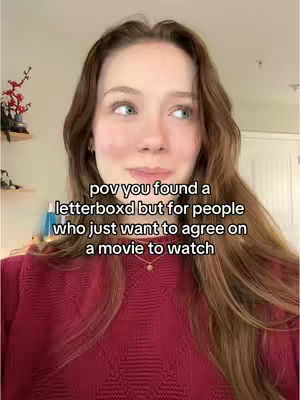 A selfie-style video featuring a young woman with long, wavy brown hair in a red sweater, looking slightly upwards with a thoughtful expression, with text overlayed.