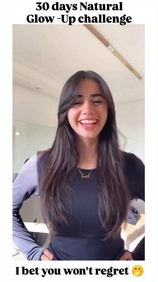 A young woman with long dark hair smiles widely, possibly laughing. She wears black clothing and a necklace. Overlaid text is visible at the top and bottom of the frame, in a vertical video format.