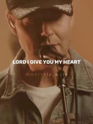 A man wearing a cap and denim jacket, singing into a microphone. Text overlayed on the image.