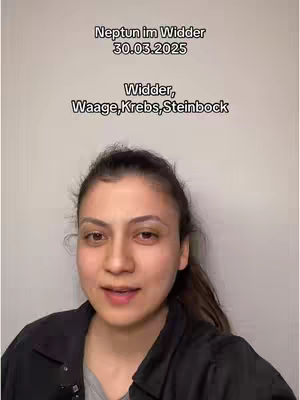 A medium shot shows a woman from the chest up, centered in the frame. She has brown hair pulled back. Text overlays in white font is at the top, and centered. The background is a plain, light color.
