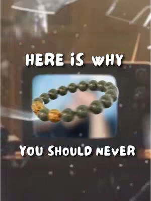 The image has a blurred background with specks resembling stars. The main focus is a green bead bracelet with golden accents, centered on the image. Text overlays read 'HERE IS WHY' in white, bold font above the bracelet, and 'YOU SHOULD NEVER' displayed in a similar style below.