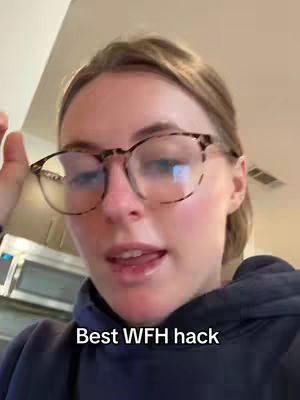 A close-up shot of a woman with blonde hair and eyeglasses, looking towards the side while speaking. The background appears to be inside a kitchen.