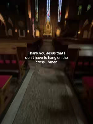 An interior shot of a church aisle with wooden pews on either side, leading towards an altar lit by stained glass windows. Text stating 'Thank you Jesus that I don't have to hang on the cross.. Amen' is overlaid on the image.