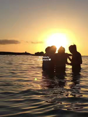 The cover image captures a serene baptism scene at sunset. Silhouetted figures stand in the water, their forms partially obscured by the bright setting sun. The water reflects the warm hues of the sunset, creating a golden glow. The text overlay reads "the beauty of baptisms" with a heart symbol.
