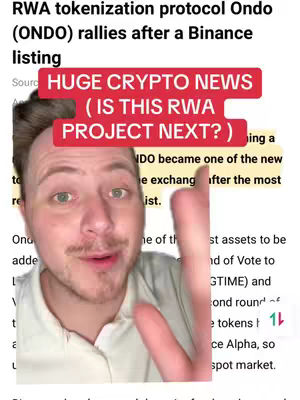 A man is centered, smiling and gesturing with his right hand. Text overlays are layered on top of a news article's backdrop, with a red rectangular callout with white text near the top. The background shows text of an article about cryptocurrency, slightly blurred, with a hand pointing at it. The text overlay reads, “HUGE CRYPTO NEWS (IS THIS RWA PROJECT NEXT?)”. The overall composition is a selfie-style video.