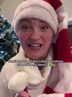 A woman wearing a Santa hat, looking at the camera with an excited expression. Text overlays the image, with a Christmas tree visible in the background.