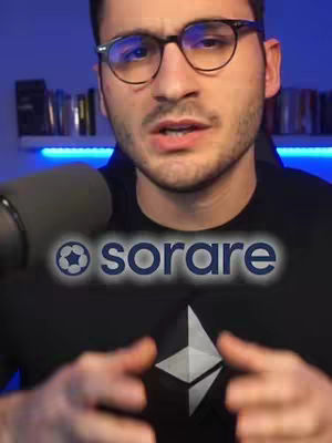 A man with glasses is centered in the frame, looking directly at the camera. Behind him is a bookshelf. He's wearing a black shirt with a logo that seems to be a geometric design beneath the superimposed text. A microphone is positioned in front of him. The composition is well-lit, with a focus on the speaker and a clear blue background.