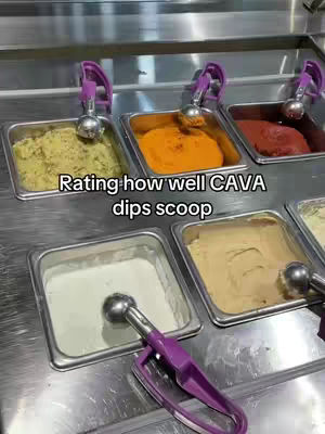 An overhead shot displays a stainless steel counter with several rectangular stainless steel containers holding various dips of different colors. Scoops with purple handles are perched in each container. There is text overlaid at the top.