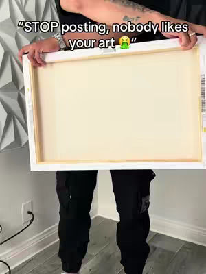 The cover image shows a person from the mid-torso down, holding a framed canvas. The person is wearing black pants with cargo pockets, black shirt. The background is a wall with a textured, geometric design.