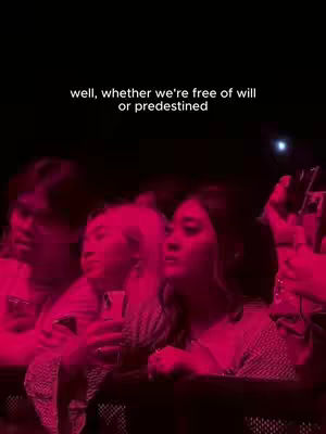 The cover image features a group of people in a dark, dimly lit setting, likely a concert or similar event. The primary color is a strong magenta or red, which bathes the scene, creating a vibrant, yet somewhat mysterious vibe. The people in the foreground are partially visible with their facial expressions, indicating engagement. There is text written on the image against the dark backdrop, suggesting it's music-related content.