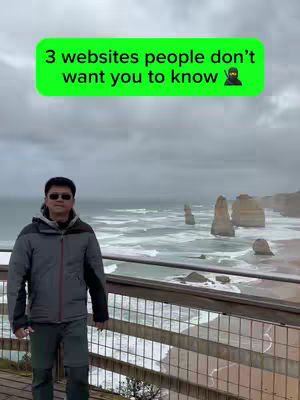 A man stands on a wooden platform overlooking a picturesque ocean view with a cloudy sky. A green banner with white text overlays the top of the image. The man wears sunglasses, a gray jacket, and dark pants. The ocean has rough waves, and there are rock formations in the background.