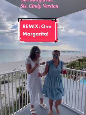 Two women are on a balcony overlooking a beach. They are dancing on a balcony with a beach and ocean background with text overlay.