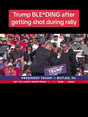 The cover image captures a chaotic scene with a crowd of people, primarily visible in the background. In the foreground, a group of people surround a figure who seems to be President Trump, and are supporting him while he is being rushed by the people and security. Above the scene, a red banner displays the text 'Trump BLE*DING after getting shot during rally'.
