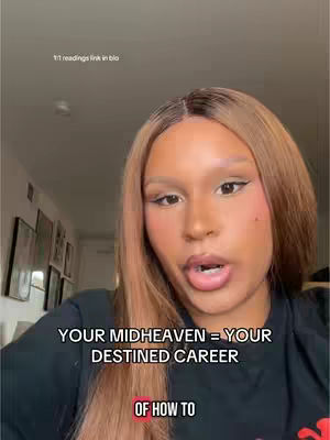 A woman with long, light brown hair and makeup is centered in the frame, looking directly at the camera with her mouth slightly open. Text overlays are present at the bottom of the image, and the background shows a portion of a room with art on the wall.