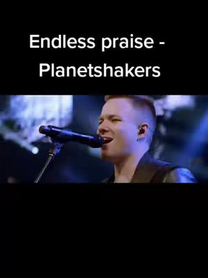 The cover image features a close-up of a man singing into a microphone. The top portion is black, with white text overlaying it. The background behind the man is blurred, but appears to be lit with blue and white lights, suggesting a stage setting.