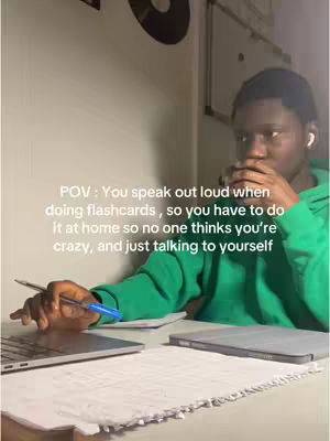 A young man wearing a green hoodie sits at a desk with a laptop and papers, looking pensive with his hand near his mouth, with text overlays.