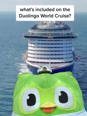 The cover image shows a cruise ship behind a plush green owl-like character, which appears to be the Duolingo mascot. In the foreground, the mascot is wearing a white sailor hat. Above the ship, a text overlay reads 'what's included on the Duolingo World Cruise?' The cruise ship is white and blue, with the ocean providing the backdrop.