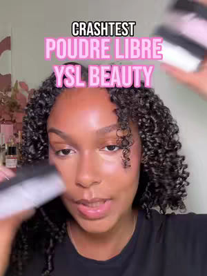 A woman with dark skin and curly hair is holding up what appears to be a makeup product. The image emphasizes her face, with text overlays at the top.