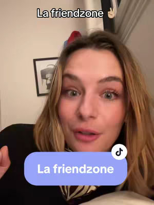A woman with blonde hair is looking towards the camera with a slightly surprised expression. She has light makeup, and the shot is from the chest up, appearing to be filmed indoors. Text above her head reads "La friendzone" and a lower blue banner says the same; there is a tiktok logo on the banner.