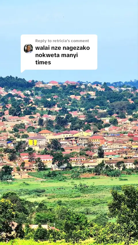 The cover image shows an aerial view of a densely populated residential area, likely a city or town. Red-roofed houses and buildings are interspersed with green trees and foliage. The sky is a clear blue, and the overall composition is a mix of natural and built environments.