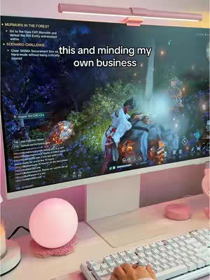 The cover image shows a PC gaming setup, featuring a large monitor displaying a vibrant game scene, a keyboard, and a pink lamp. The text overlay reads 'this and minding my own business'. The setup suggests a focus on gaming aesthetics and personal space.