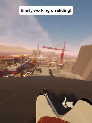 A first-person view from a parkour game, showing the player sliding down a slope in a city environment. The foreground shows the player's legs and feet in a low-poly style, while the background features a cityscape with buildings, cranes, and a bright blue sky.