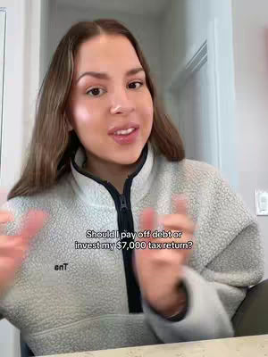 The cover image shows a woman with long brown hair and a light-colored fleece zip-up jacket. She is positioned in front of a light-colored wall and a white door frame, with her hands in front of her. Text overlay in image reads, "Should I pay off debt or invest my $7,000 tax return?"