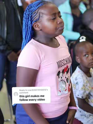 A young girl with blue braided hair wearing a pink t-shirt with a Mickey and Minnie Mouse graphic and a small pink wristband, with a white text box overlay.