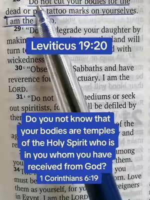 A close-up shot over a page of a book. The page is open to scriptural context with a blue pen laying across the text. Text boxes highlight verses of scripture.