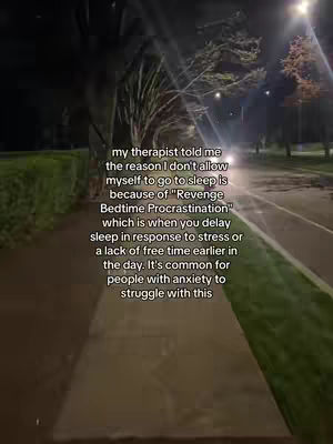 The image is a vertical shot of a pathway at night, likely a sidewalk or a paved trail, with trees and streetlights providing light for the scene. Text overlayed on the image provides context.