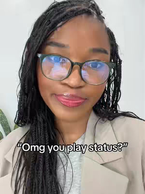 A close-up shot of a woman wearing glasses and a blazer, with text overlay. She has dark hair styled in braids, and is looking at the camera with a slight smile. The background is a plain wall.