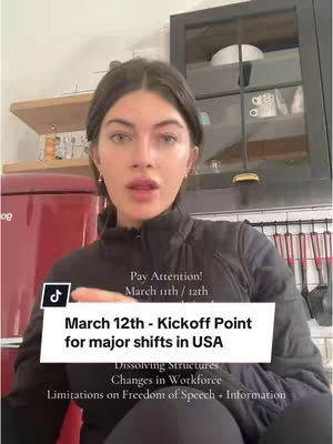 A woman is in the foreground, facing forward and looking slightly upwards. She has dark hair and is wearing a black jacket. In the background, there is a red refrigerator and some shelving. The video has overlaying text that gives information about a date and what will take place on that day.