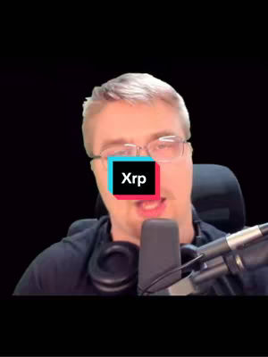 A close-up shot of a man with glasses and a black shirt looking directly at the camera. A multi-colored square reading 'Xrp' covers his mouth. The background is a solid black.