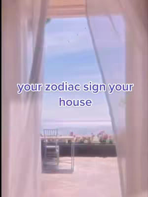 A view through a window with white curtains, showing a table and chairs outdoors with a floral display and a body of water and the sky in the background, with the text overlayed 'your zodiac sign your house'.