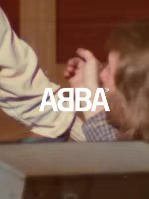 The image shows a close-up view of two people, with the ABBA logo prominently displayed. The right side shows a person with blonde hair, with a face only partly visible. On the left, an arm is extended, holding a hand. The background is a mix of reddish and brown tones, with the classic ABBA logo in white at the lower center.