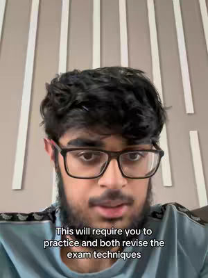 A selfie style shot of a young man with black hair, glasses and a beard. Behind him there is a white and light gray wall. Text overlayed at the bottom.