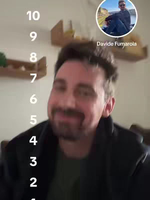 The cover image features a man's face prominently in the foreground, slightly blurred, suggesting a close-up shot. He has short, dark hair, a mustache, and a beard. He's wearing a dark jacket over a green shirt. To the upper-right, there's a circular inset containing a photo of another man wearing sunglasses, with text 'Davide Fumarola' below the photo. On the left, a white vertical list from 10 to 1 is placed.