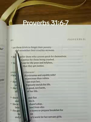 The image shows an open book with text from Proverbs 31. A silver pen rests on the page, and a yellow ribbon is visible in the background. The text reads 'Proverbs 31:6-7' at the top.