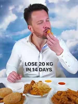 A man in a white shirt is about to eat a piece of food. He's sitting in front of a table laden with food and a backdrop of a cloudy sky.