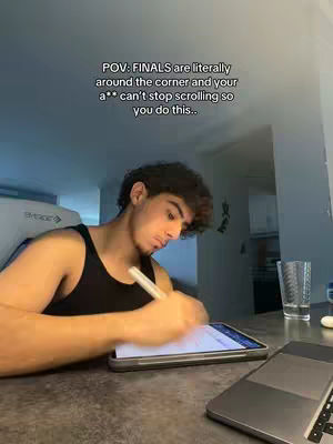 A young man with dark curly hair is seated at a desk, writing on a tablet with a stylus. Text on the image reads "POV: FINALS are literally around the corner and your a** can't stop scrolling so you do this..." The scene is lit with natural light, suggesting a daytime study environment.